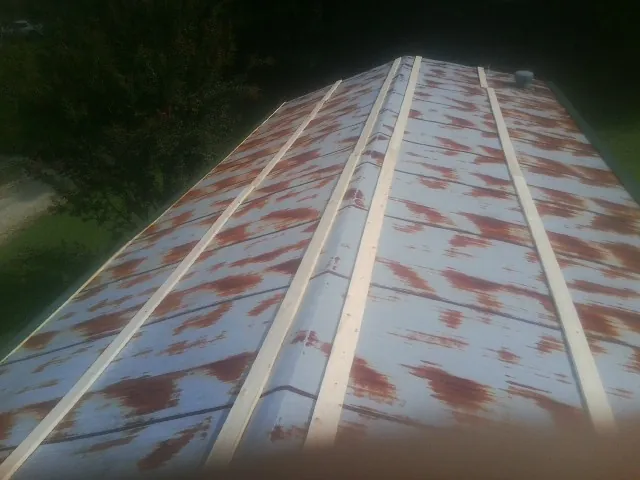 Rusted metal roof panels with new wood purlins before replacement — Storm Damage Roof Repair in Brookside by Roofing Brothers